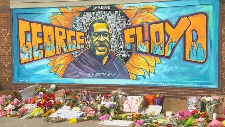 George Floyd mural with flowers underneath